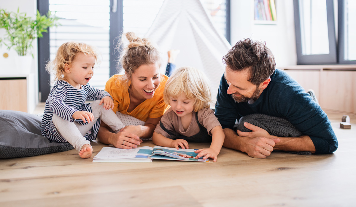 family reading a book on wood look floor
